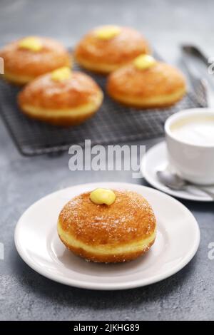 Hausgemachte Bomboloni gefüllt mit Pudding, italienische gefüllte Donuts. Stockfoto