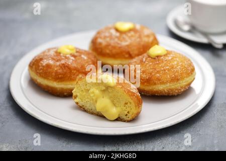 Hausgemachte Bomboloni gefüllt mit Pudding, italienische gefüllte Donuts. Stockfoto