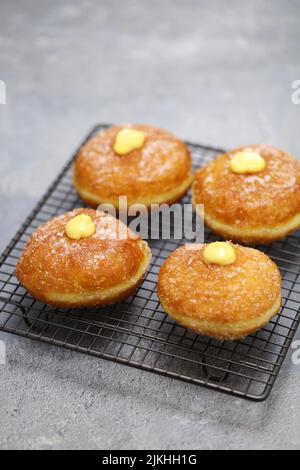 Hausgemachte Bomboloni gefüllt mit Pudding, italienische gefüllte Donuts. Stockfoto