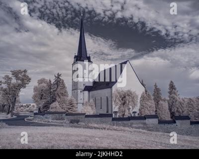 Eine alte schwarz-weiß verlassene Kirche auf dem Land unter dem wolkigen Himmel Stockfoto