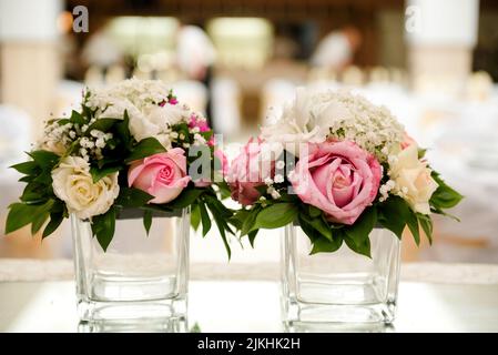 Die Blumensträuße in einer transparenten Glasvase auf einem verschwommenen Hintergrund Stockfoto