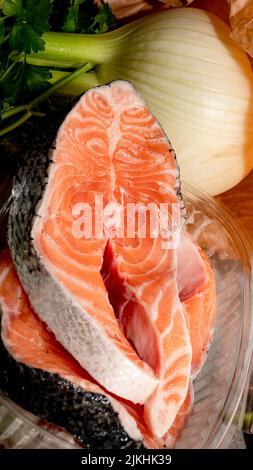 Gebratene Lachssteaks mit Gemüse auf einem Holztisch Stockfoto