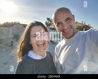 Attraktives spanisches Paar mittleren Alters, das sich gemeinsam amüsiert und fröhlich lacht und scherzte. Stockfoto