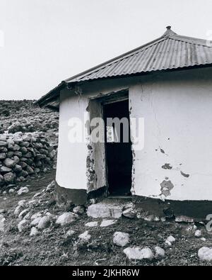 Eine vertikale Graustufenaufnahme eines alten verlassenen Rondavel, Eastern Cape Stockfoto