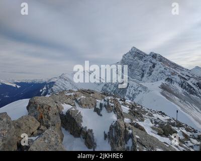 Eine schöne Aufnahme von felsigen Bergen, die teilweise mit Schnee bedeckt sind. Stockfoto