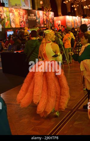 Eine vertikale Aufnahme einer Frau im Cosplay mit vielen rosa Schwänzen auf einer Videospiel-expo in Wien, Österreich Stockfoto