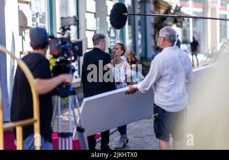 Schwerin, Deutschland. 02. August 2022. Daniel Eichinger als Chefrezeption und Barbara Prakopenka in der Rolle von Dominique Färber während der Dreharbeiten für die neue ZDF-Serie „Hotel Mondial. Das imaginäre 4-Sterne-Hotel 'Mondial', das auf eine lange Tradition zurückblicken kann, bildet den Rahmen für das Grundstück. Nach Angaben der Produktionsfirma wird die erste Staffel aus zwölf Episoden bestehen und im nächsten Jahr mittwochs ausgestrahlt. Quelle: Jens Büttner/dpa/Alamy Live News Stockfoto