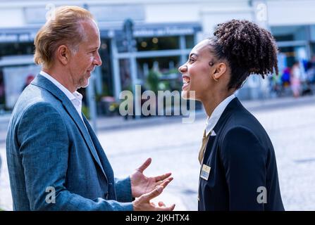 Schwerin, Deutschland. 02. August 2022. Joy Ewulu als Lara Hildebrand und Wolfgang Hildebrandt als ihr Vaterstar bei den Dreharbeiten für die neue ZDF-Serie „Hotel Mondial. Das Grundstück befindet sich im imaginären 4-Sterne-Hotel Mondial, das auf eine lange Tradition zurückblicken kann. Nach Angaben der Produktionsfirma wird die erste Staffel aus zwölf Episoden bestehen und im nächsten Jahr mittwochs ausgestrahlt. Quelle: Jens Büttner/dpa/Alamy Live News Stockfoto