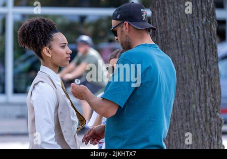 Schwerin, Deutschland. 02. August 2022. Joy Ewulu in der Rolle von Lara Hildebrand wird während der Dreharbeiten für die neue ZDF-Serie „Hotel Mondial“ mit einem Mikrofon verkabelt. Das imaginäre 4-Sterne-Hotel 'Mondial', das auf eine lange Tradition zurückblicken kann, bildet den Rahmen für das Grundstück. Nach Angaben der Produktionsfirma wird die erste Staffel aus zwölf Episoden bestehen und im nächsten Jahr mittwochs ausgestrahlt. Quelle: Jens Büttner/dpa/Alamy Live News Stockfoto