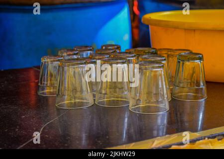 Stock Foto von gewaschenen Glas-Teetassen auf schwarzen Granit Küchentheke im Hotel auf verschwommenem Hintergrund gehalten. Bild aufgenommen in Gulbarga, Karnataka, I Stockfoto