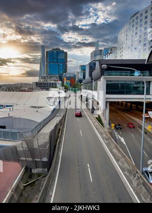 Wolkenkratzer unter dunklen Wolken im Geschäftsviertel von Sydney, die Sydney Highway Bridge und Skyline unter dunklen Wolken Stockfoto