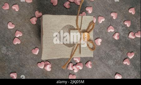 Ansicht einer Geschenkbox, rosafarbene Herzen ringsum, Draufsicht Stockfoto