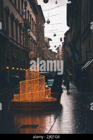 Eine vertikale Weitwinkelaufnahme der Straße von Florenz mit Dekorationen für den Urlaub Stockfoto