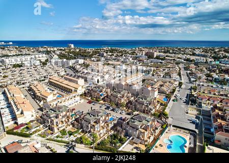 Wohnviertel Stadtbild Dächer von Cabo Roig Luftbild Küste spanische Stadt, Mittelmeer und blau bewölkten Himmel an sonnigen Sommertag. Trave Stockfoto