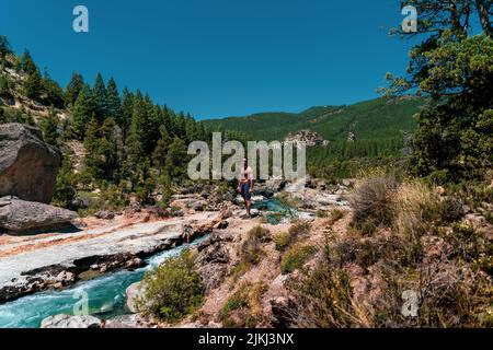 Ein junger hispanischer Kerl in Sonnenbrille, der an einem Fluss in Argentinien steht Stockfoto