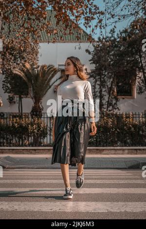 Porträt einer jungen Dame, die die Straße überquert Stockfoto