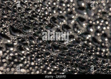 Eine selektive Aufnahme großer und kleiner Blasen in einem Glas als Hintergrund Stockfoto