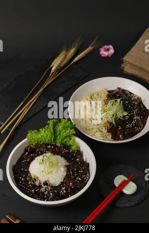 Eine vertikale Aufnahme von Schüsseln mit Nudeln mit schwarzer Bohnensauce Stockfoto