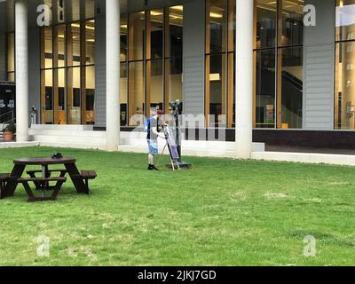 Ein Student bewundert die Malerei auf einem Stand in einem Innenhof der Universität Stockfoto