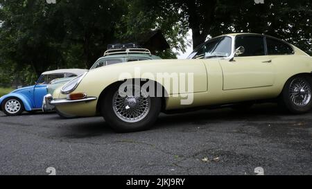 Ein alter Oldtimer ein gelber Jaguar E Type parkte auf der Straße Stockfoto