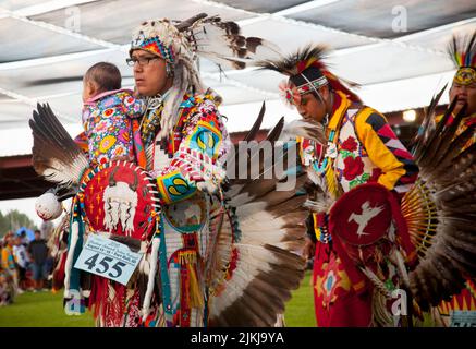 Die POW Wow-Tänzerin hält ihr Baby beim Tanzen im Shoshone Bannock Pow Wow, Fort Hall, Idaho Stockfoto