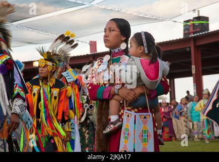 Die POW Wow-Tänzerin hält ihr Baby beim Tanzen im Shoshone Bannock Pow Wow, Fort Hall, Idaho Stockfoto