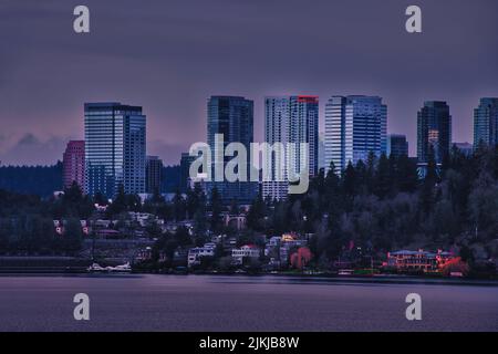 Ein entfernter Blick auf die Skyline der Innenstadt von Bellevue mit See im Vordergrund in Washington, USA Stockfoto