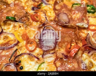Eine Nahaufnahme der Pizza mit Scheiben aus Zwiebel, Pfeffer, Jalapeno und Käse Stockfoto