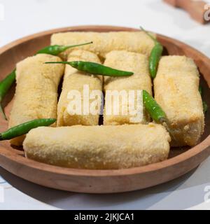 Eine Nahaufnahme von hausgemachten indonesischen Frikadellen mit einer Mischung aus Huhn, Karotten und Kartoffeln und mit Paniermehl überzogen auf einem braunen Keramikplatte Stockfoto