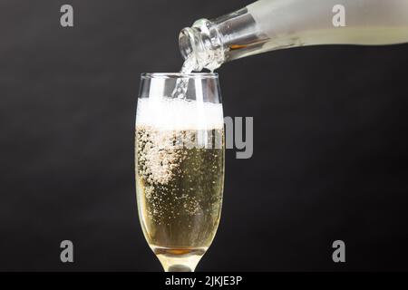 Eine Nahaufnahme eines Glases Champagner auf schwarzem Hintergrund Stockfoto
