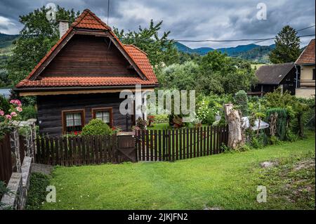 Ein grüner Garten eines kleinen Holzhauses in einem Dorf Stockfoto