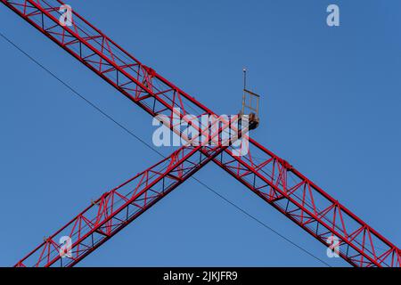 Eine Aufnahme eines großen, roten Konstruktionskrans in einem niedrigen Winkel gegen einen blauen Himmel Stockfoto