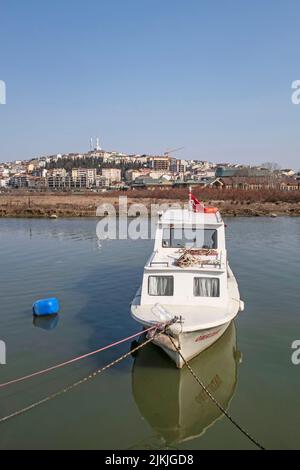 Eine wunderschöne Aufnahme eines Bootes am Dock am Ufer des Goldenen Horns mit blauem Horizont in Istanbul, Türkei Stockfoto