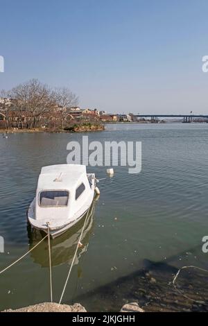 Eine wunderschöne Aufnahme eines Bootes am Dock am Ufer des Goldenen Horns mit blauem Horizont in Istanbul, Türkei Stockfoto