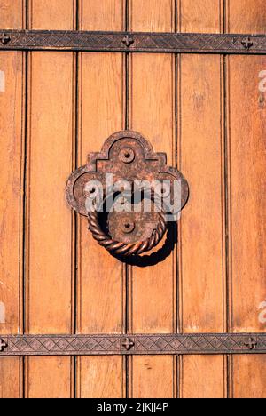 Eine vertikale Nahaufnahme des Türklopfers an der alten Holztür. Stockfoto