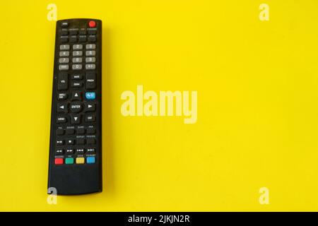tv-Fernbedienung auf gelbem Hintergrund isoliert Stockfoto