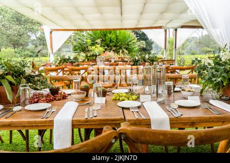Ein Veranstaltungsort für Abendessen im Freien mit Holztischen Stockfoto