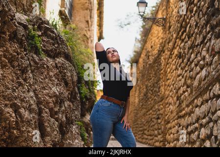 Eine wunderschöne kaukasische Frau, die in einer engen Gasse posiert Stockfoto