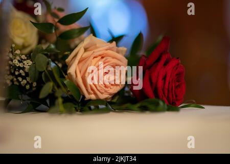 Eine Nahaufnahme der schönen rosa und roten Rosen, die zur Dekoration auf einem Tisch des Restaurants platziert wurden Stockfoto