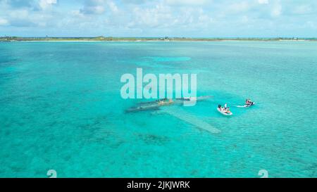 Eine Luftaufnahme von Menschen in einem weißen winzigen Boot in Exumas, Bahamas Stockfoto