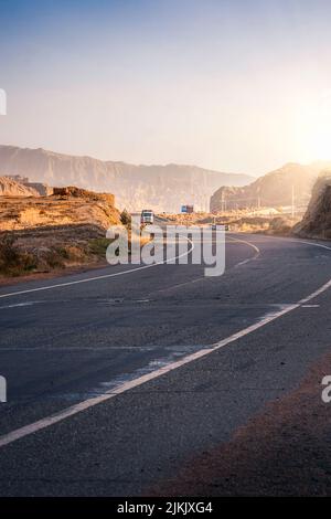 Eine vertikale Aufnahme einer leeren Autobahn inmitten von Klippen unter dem klaren Himmel Stockfoto