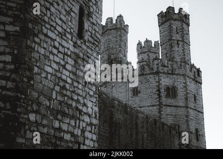 Eine Graustufenaufnahme des Caernarfon Castle (walisisch: Castell Caernarfon) in Gwynedd, Wales Stockfoto