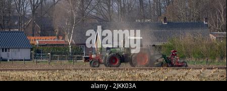 Ein Fendt-Traktor, der in Nederweert, Niederlande, durch das Feld pflügt Stockfoto