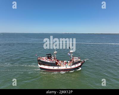 Eine Luftaufnahme der Yacht auf dem Wasser und den grünen Inseln Stockfoto