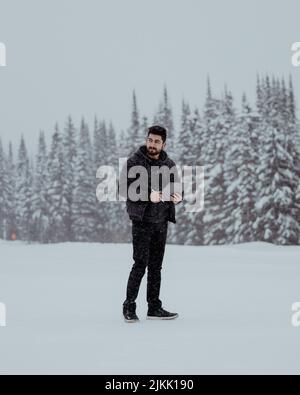 Nahaufnahme eines Mannes, der im Winter auf einem Schnee auf einem Hügel steht Stockfoto