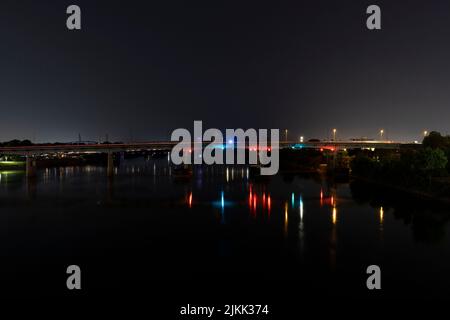 Eine wunderschöne Aufnahme einer Brücke mit bunten Lichtern über dem Fluss bei Nacht in Little Rock, Arkansas, USA Stockfoto