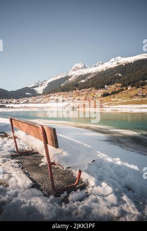 Eine vertikale Aufnahme einer Bank in Breil oder Brigels im Schnee, einer Gemeinde in Surselva, Schweiz Stockfoto