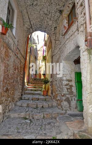 Eine vertikale Aufnahme eines schmalen Korridorweges mit einer alten Treppe in Italien. Stockfoto