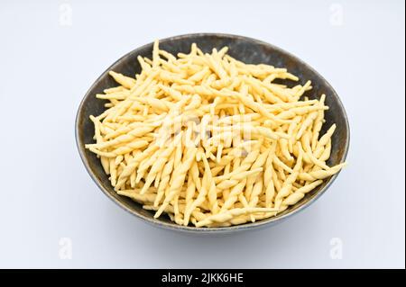 Eine Nahaufnahme von roher Trofie-Pasta auf weißem Hintergrund Stockfoto