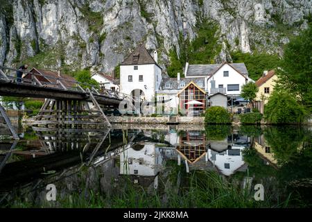 Idyllischer Blick auf das Dorf Markt Essing in Bayern, Deutschland mit der Altmühl und hohen Klippen an einem sonnigen Tag im Frühjahr Stockfoto